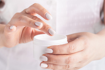 Adult woman applying hand cream, closeup