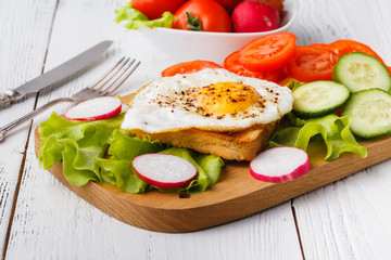 Fototapeta na wymiar Breakfast - bread toast with poached egg, spices and arugula