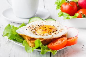 crispy toast with a fried egg and fresh arugula, a cup of coffee, breakfast in hotel room