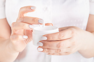 Closeup shot of woman hands applying moisturizing hand cream