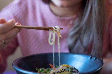 Obraz premium girl eating noodles with seafood