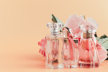 Bottle of perfume with flowers on light cloth