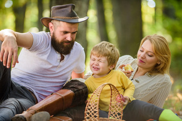 Enjoying summer rest. Spring mood. Happy family day. Sunny weather. Healthy food. Family picnic. Happy son with parents relax in autumn forest. Mother, cowboy father love their little boy child