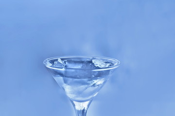 drink in a martini glass with ice cubes.
