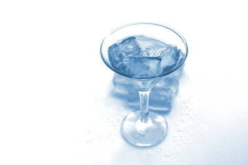 drink in a martini glass with ice cubes.