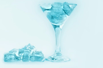 drink in a martini glass with ice cubes.