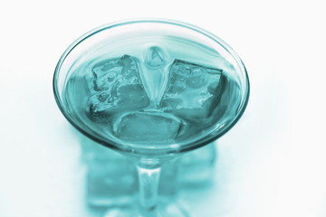 drink in a martini glass with ice cubes.