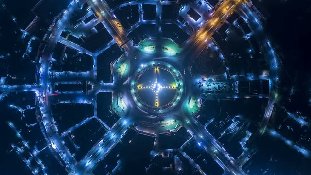Hyperlapse timelapse of night city traffic on 4-way stop street intersection circle roundabout in bangkok, thailand. 4K UHD horizontal aerial view.