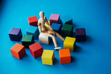 Obraz premium The wooden man thinks about the idea. Brainstorm.Fresh ideas, problem solving, joint actions - the concept of people's emotional relationships.