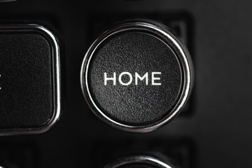 A close-up or macro shot of the round HOME key of a black antique style typewriter keyboard in horizontal image format.