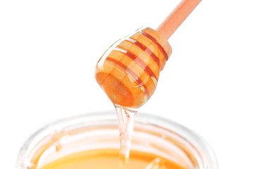 Honey stick with flowing honey isolated on white background