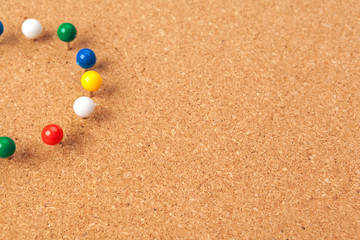Group of thumbtacks pinned on corkboard