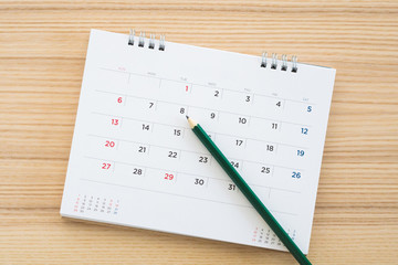 calendar page with pencil on wood table background