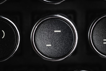 A close-up or macro shot of the round dash and minus key of a black antique style typewriter...