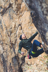 Obraz premium Mężczyzna wspina się na skałę.