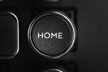 A close-up or macro shot of the round HOME key of a black antique style typewriter keyboard in horizontal image format.