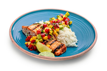 Delicious grilled salmon steak on a blue plate with jasmine rice and sauce made of mango, bell...