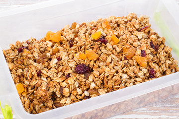 granola with berries in plastic container