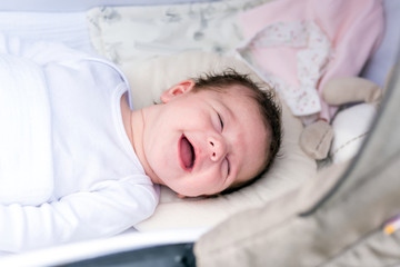 Fototapeta na wymiar Portrait of a baby girl lying in a stroller