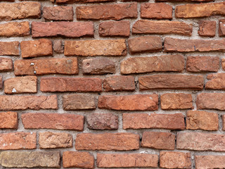 the old wall of red brick destroyed by wind and water