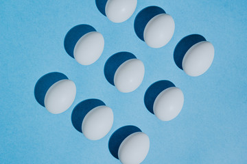 White chicken eggs  with empty space, on a blue background. Abstract image