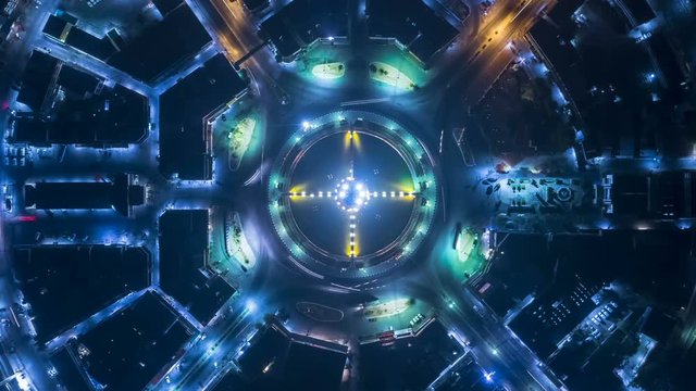 Hyperlapse timelapse of night city traffic on 4-way stop street intersection circle roundabout in bangkok, thailand. 4K UHD horizontal aerial view.