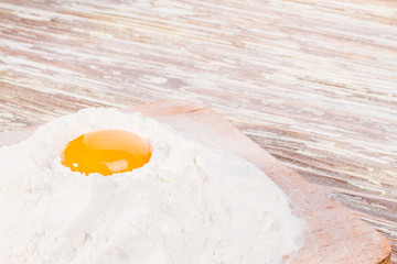 on wooden background egg in flour