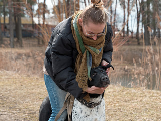 girl walking a big blind dog in the spring