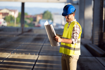 Picture of construction site engineer looking at plan