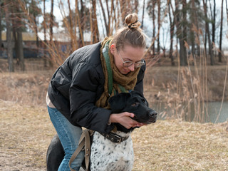 girl walking a big blind dog in the spring