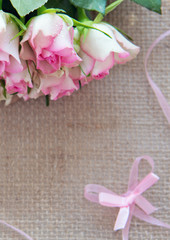 Pink roses and loop isolated on brown cloth Background.