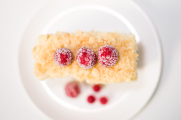 cake with raspberries and currants on a plate