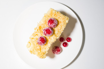 cake with raspberries and currants on a plate