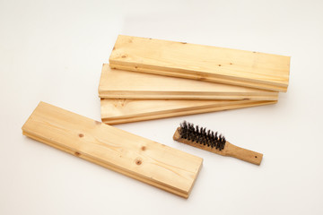Hand wire brush on wooden pine Board. Aging wooden boards by brushing. White background.