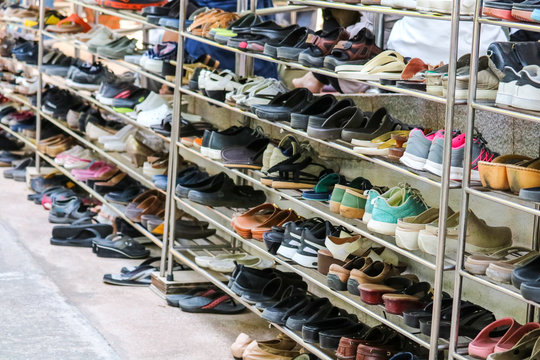 Shoes are organized in an orderly manner on shelves inside a temple