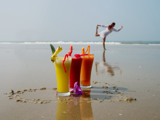 Three glasses of freshly squeezed fruit juice on the seashore