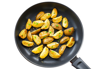 Fresh fried potato wedges with rosemary and spring onion on a pan, isolatedon white background, top view close-up shot