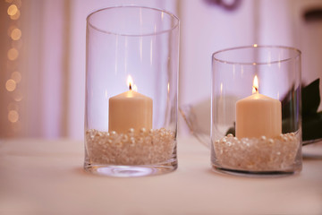 Fototapeta na wymiar candles on a glass candlestick. Burning candle in a round glass candlestick with decorative seashells