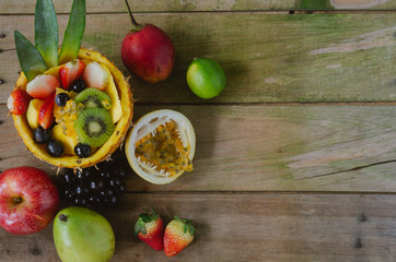 Varied fruits on rustic wooden background. Flat lay.