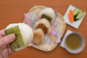 女性の手と和食のおにぎり