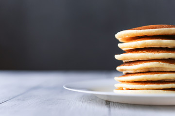 fresh classic pancake stacked in stack on gray background with place for text - obrazy, fototapety, plakaty