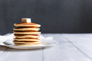 fresh classic pancake stacked in stack on gray background with place for text