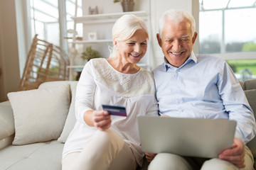 Senior couple using laptop computer at home