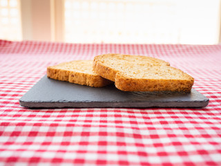 Two slices of toast on a slate plate and tablecloth vintage style
