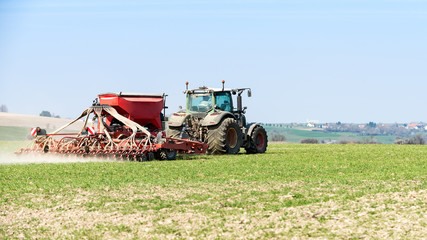 Fototapeta premium tracteur agricole en action sur le champ au printemps