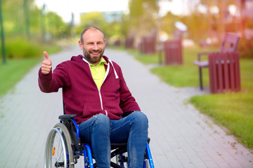 happy man on wheelchair showing OK