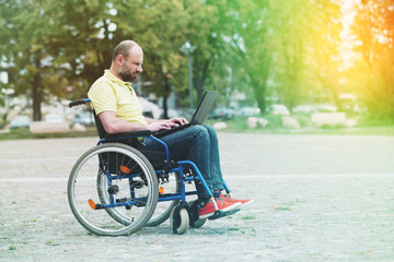 man on wheelchair working on laptop
