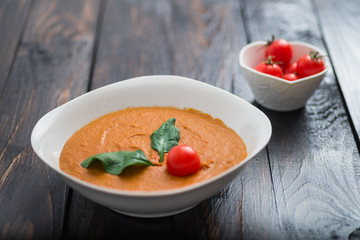 Pumpkin and carrot cream soup with  parsley in  a white bowl on dark wooden background. Rustic, food.