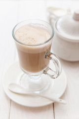 Raf coffee in transparent glass on a light wooden background. Delicious Russian most popular drinks. 