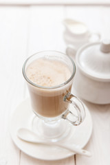 Raf coffee in transparent glass on a light wooden background. Delicious Russian most popular drinks. 